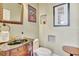 Stylish powder room featuring a dark vanity with granite countertop, decorative mirror, and updated fixtures at 1108 W Charter St, Tampa, FL 33602