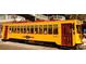 Vintage yellow streetcar with red accents, providing transit service in the historic district of Tampa at 1108 W Charter St, Tampa, FL 33602