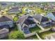 Community aerial view showcasing houses, landscaping, a pond, and wooded area at 1571 Montgomery Bell Rd, Wesley Chapel, FL 33543