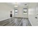 Bright bedroom featuring wood-look flooring, a chandelier, and natural light from two windows at 1571 Montgomery Bell Rd, Wesley Chapel, FL 33543