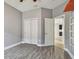 Neutral bedroom with double closets and view of kitchen with hardwood style flooring at 1571 Montgomery Bell Rd, Wesley Chapel, FL 33543