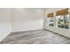 Bright, empty bedroom with wood floors, two windows, and fresh paint at 1571 Montgomery Bell Rd, Wesley Chapel, FL 33543