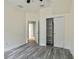 Bright bedroom with wood-look floors, closet with shelving, and ensuite bathroom access at 1571 Montgomery Bell Rd, Wesley Chapel, FL 33543