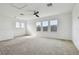 Large bonus room featuring neutral carpet, ample windows, and a ceiling fan at 1571 Montgomery Bell Rd, Wesley Chapel, FL 33543