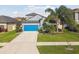 Charming two-story home with a bright blue garage door and well-manicured lawn and landscaping at 1571 Montgomery Bell Rd, Wesley Chapel, FL 33543