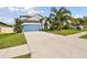 Charming two-story home featuring a well-manicured lawn and a spacious driveway leading to a blue garage door at 1571 Montgomery Bell Rd, Wesley Chapel, FL 33543