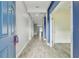 Long hallway with wood-look tile flooring and contrasting blue and gray walls at 1571 Montgomery Bell Rd, Wesley Chapel, FL 33543