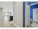 Hallway featuring an adjacent bathroom, kitchen, and living area with modern tile flooring at 1571 Montgomery Bell Rd, Wesley Chapel, FL 33543
