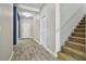 Inviting hallway with wood-look tile, staircase, and neutral paint scheme at 1571 Montgomery Bell Rd, Wesley Chapel, FL 33543