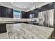Bright kitchen featuring granite counters, stainless appliances, and stylish dark cabinetry at 1571 Montgomery Bell Rd, Wesley Chapel, FL 33543