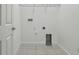 Functional laundry room with tile flooring, utility connections, and access door at 1571 Montgomery Bell Rd, Wesley Chapel, FL 33543