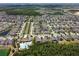 Extensive aerial view showcases a vibrant neighborhood with a pool, lush landscaping, and well-maintained homes at 1571 Montgomery Bell Rd, Wesley Chapel, FL 33543