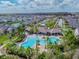 Aerial view of a stunning pool and clubhouse area, surrounded by palm trees and beautiful landscaping in a neighborhood at 1571 Montgomery Bell Rd, Wesley Chapel, FL 33543