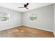Bright, empty bedroom with hardwood floors, and two windows at 1600 Connecticut Ne Ave, St Petersburg, FL 33703
