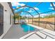 A screened-in pool with a unique rock feature, surrounded by a patio at 1600 Connecticut Ne Ave, St Petersburg, FL 33703