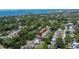 Aerial view of cozy property with backyard pool, lush trees, and a glimpse of the serene bay, perfect for relaxation at 1623 San Mateo Dr, Dunedin, FL 34698