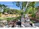 Seating area in a serene backyard with a lush garden and mature trees creating a private oasis at 1623 San Mateo Dr, Dunedin, FL 34698