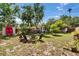 Spacious backyard with mature trees, a shed, and cozy outdoor seating area with room to add a pool at 1623 San Mateo Dr, Dunedin, FL 34698