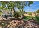 Lush backyard featuring mature trees, outdoor seating, and well-manicured landscaping for a tranquil escape at 1623 San Mateo Dr, Dunedin, FL 34698