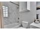 Bathroom featuring a marble-tiled shower-tub combination with a glass block window for natural light at 1623 San Mateo Dr, Dunedin, FL 34698