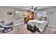 Comfortable bedroom with soft carpet, ceiling fan, and natural light through large windows at 1623 San Mateo Dr, Dunedin, FL 34698