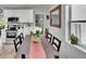 Bright dining room features hardwood floors, and a long dining table with white flower centerpiece at 1623 San Mateo Dr, Dunedin, FL 34698