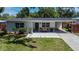 Single-story home boasts a lovely front yard, stylish walkway, and a convenient attached carport at 1623 San Mateo Dr, Dunedin, FL 34698