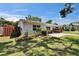 Well-manicured front yard with green lawn and mulch bed, leading to a cozy home with a golf cart at 1623 San Mateo Dr, Dunedin, FL 34698