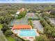 Aerial view of community pool, tennis courts, and clubhouse, surrounded by mature trees at 17003 Madres De Avila, Tampa, FL 33613