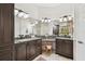 Elegant bathroom boasts a double vanity with granite countertops, makeup table, framed mirrors, and travertine floors at 17003 Madres De Avila, Tampa, FL 33613