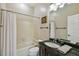 Well-lit bathroom features a shower and tub combination, dark wood vanity, and neutral wall color at 17003 Madres De Avila, Tampa, FL 33613