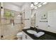 Stylish bathroom features a glass-enclosed shower, black granite countertop, and modern fixtures at 17003 Madres De Avila, Tampa, FL 33613