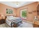 Cozy bedroom features a queen-sized bed, decorative art, large window with built-in seat, and neutral decor at 17003 Madres De Avila, Tampa, FL 33613