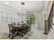 Formal dining room featuring a chandelier, tray ceiling, large window, and seating for eight at 17003 Madres De Avila, Tampa, FL 33613
