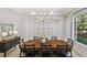 Dining room with a wooden table, black chairs, chandelier, and view of backyard at 17003 Madres De Avila, Tampa, FL 33613