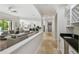 Hallway with marble floors, a wet bar, and a view into the living room and kitchen area at 17003 Madres De Avila, Tampa, FL 33613