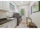 Convenient laundry room with washer, dryer, sink, and storage cabinets at 17003 Madres De Avila, Tampa, FL 33613