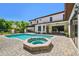 A large pool and spa with brick surround and views of the beautiful, landscaped backyard at 17003 Madres De Avila, Tampa, FL 33613