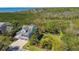 Expansive aerial view of a coastal home with lush greenery, a garden, and ocean views at 1720 Mariner Way, Tarpon Springs, FL 34689