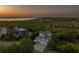 Breathtaking aerial view of a waterfront home surrounded by lush greenery, offering scenic sunset vistas at 1720 Mariner Way, Tarpon Springs, FL 34689