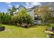 Lush backyard with seating area and mature trees, offering a peaceful outdoor space at 1720 Mariner Way, Tarpon Springs, FL 34689