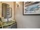 Stylish powder room features a modern glass sink, updated fixtures, decorative mirror, and lovely wall art at 1720 Mariner Way, Tarpon Springs, FL 34689