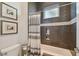 Modern bathroom featuring a tiled shower/tub combination, decorative niche, and elegant gray tilework and fixtures at 1720 Mariner Way, Tarpon Springs, FL 34689