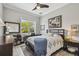 Inviting bedroom with a ceiling fan, desk, and large window; the comfortable bed is adorned with a patterned quilt at 1720 Mariner Way, Tarpon Springs, FL 34689