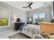 Well-lit bedroom featuring a ceiling fan, a large window, dresser with TV, and a comfortable bed with stylish linens at 1720 Mariner Way, Tarpon Springs, FL 34689