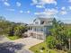 Beautiful coastal home with an elevated porch, lush landscaping, and a long driveway at 1720 Mariner Way, Tarpon Springs, FL 34689
