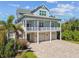 Inviting coastal home featuring a double porch, a well-maintained yard, and a spacious driveway at 1720 Mariner Way, Tarpon Springs, FL 34689