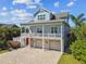 Charming coastal home with an inviting front porch, lush landscaping, and a spacious driveway at 1720 Mariner Way, Tarpon Springs, FL 34689