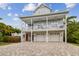 Beautifully elevated coastal home with a large porch, spacious driveway, and a convenient two-car garage at 1720 Mariner Way, Tarpon Springs, FL 34689