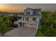 Charming two-story home with a large driveway, featuring a double balcony, three-car garage and lush landscaping at 1720 Mariner Way, Tarpon Springs, FL 34689
